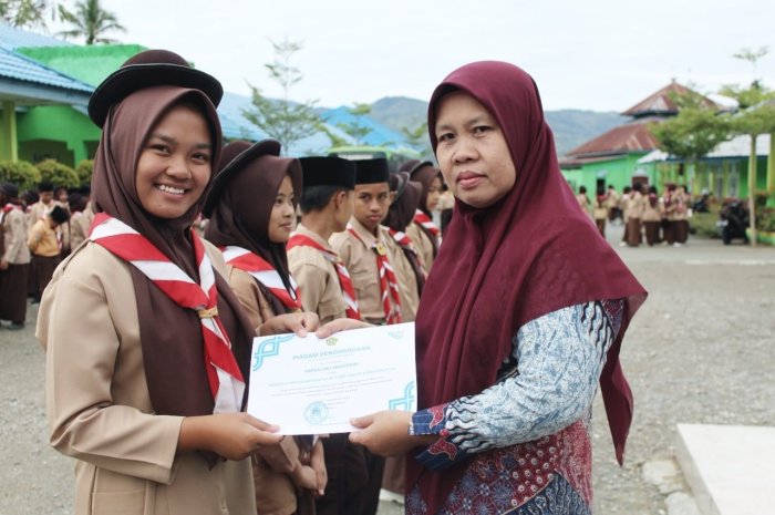 Penyerahan Piagam dan Reward kepada Peserta OMI MTsN 1 Kerinci oleh KAUR TU, Ibu Rahma Bifa Elqies, S.E
